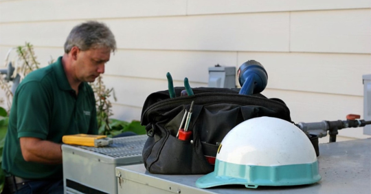HVAC technician troubleshooting an outdoor condenser unit