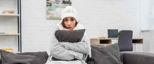 woman shivering inside cold house